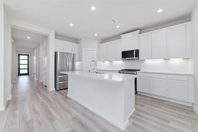 a kitchen with refrigerator cabinets and wooden floor