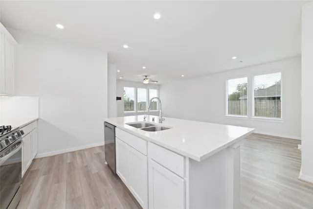 a kitchen with a sink and wooden floor