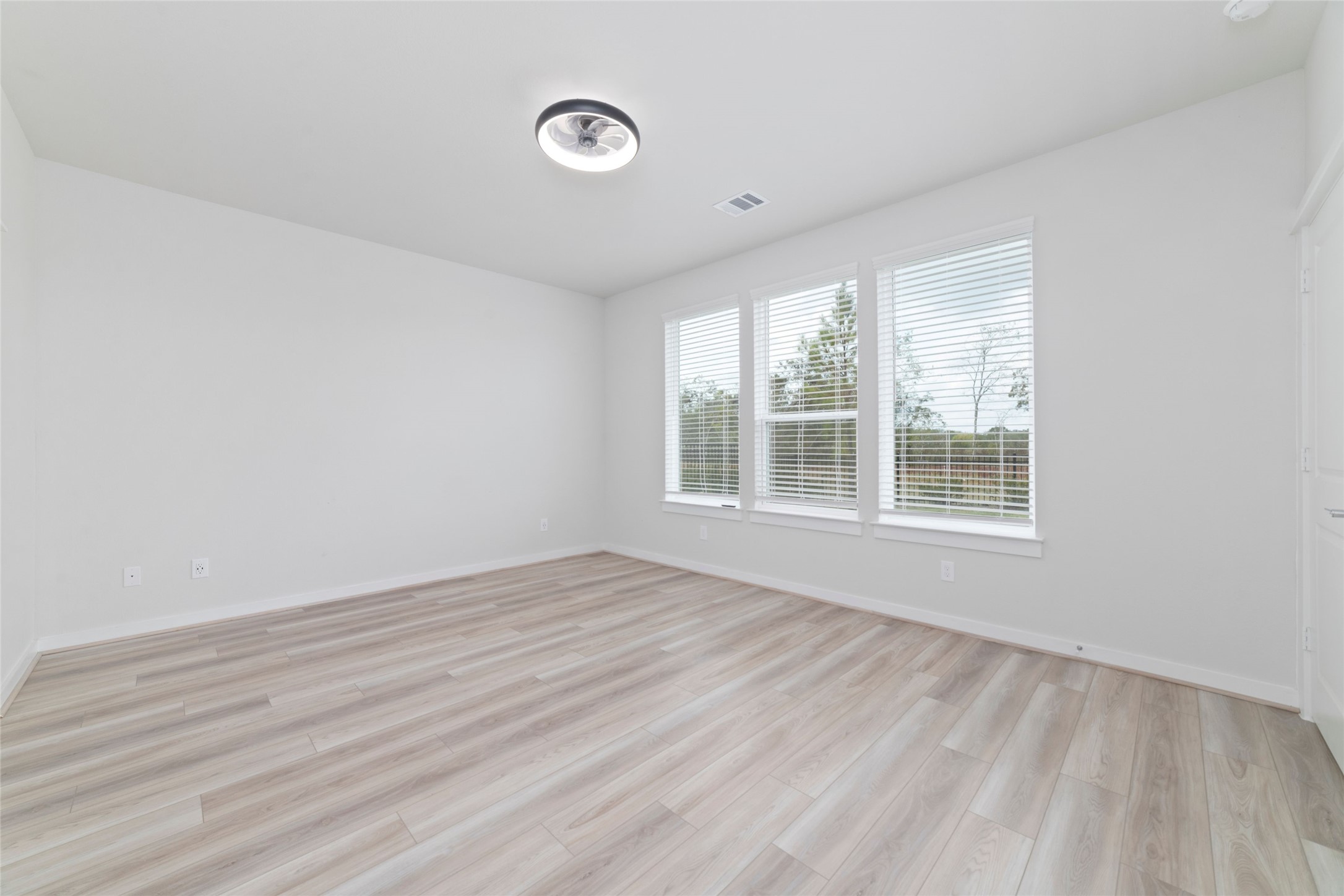 32906 School Hl Road Fulshear, TX 77441 - Photo 19 of 25 an empty room with wooden floor and windows