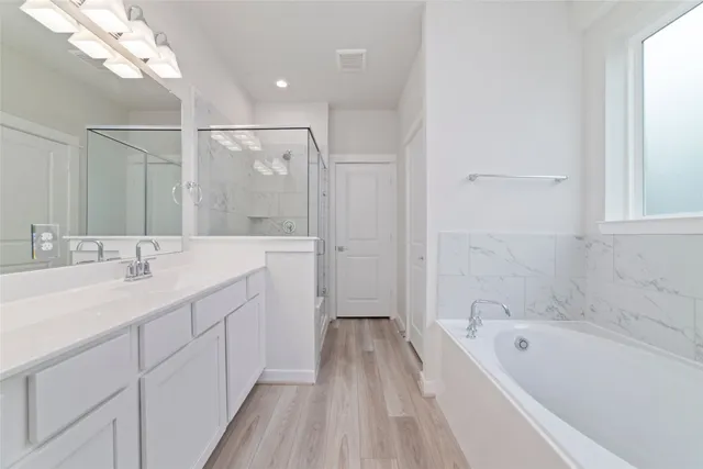 a bathroom with a tub a sink and mirror