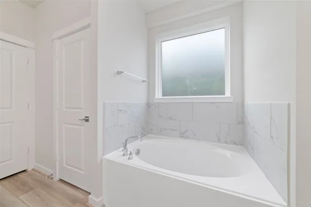 a white bath tub sitting next to a shower