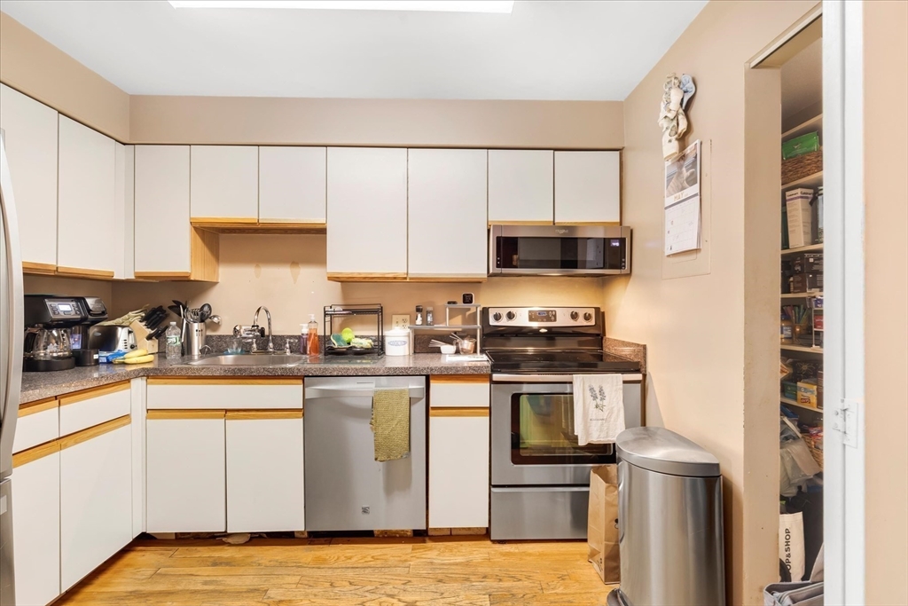 106 13th Street, Unit 114 Boston, MA 02129 - Photo 9 of 42 a kitchen with stainless steel appliances granite countertop a stove a sink and a microwave