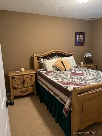 a bed sitting in a bedroom next to a lamp