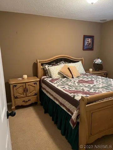 a bed sitting in a bedroom next to a lamp