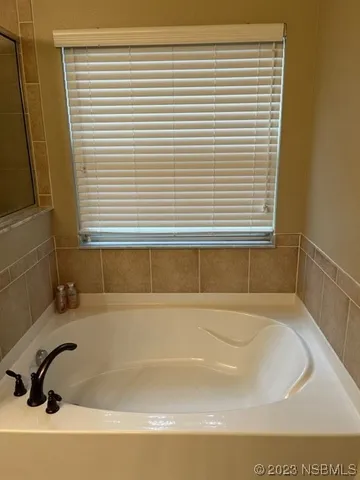 a bathroom with bathtub and a window