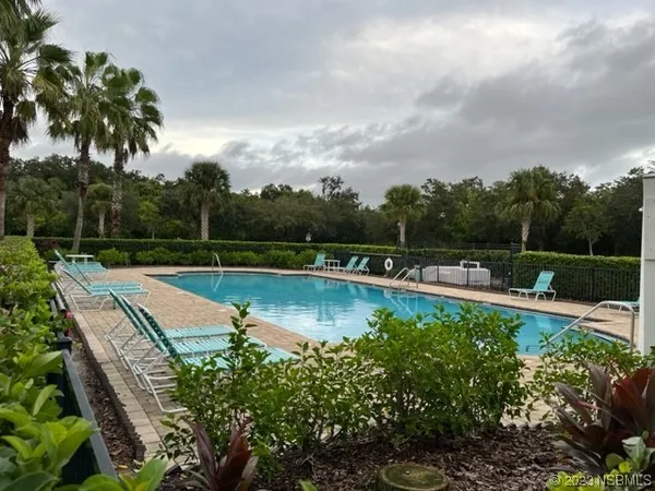 a view of a swimming pool with a patio and a yard