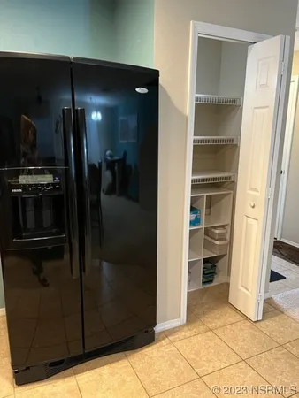 a view of a refrigerator in kitchen and a living room