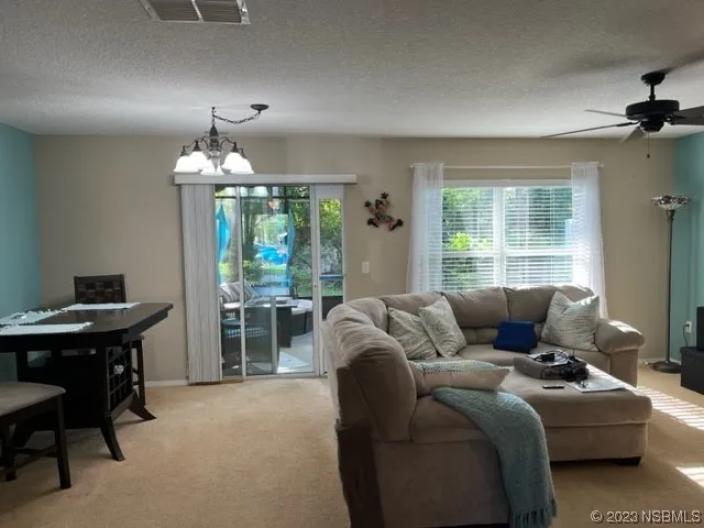 a living room with furniture a chandelier and a window