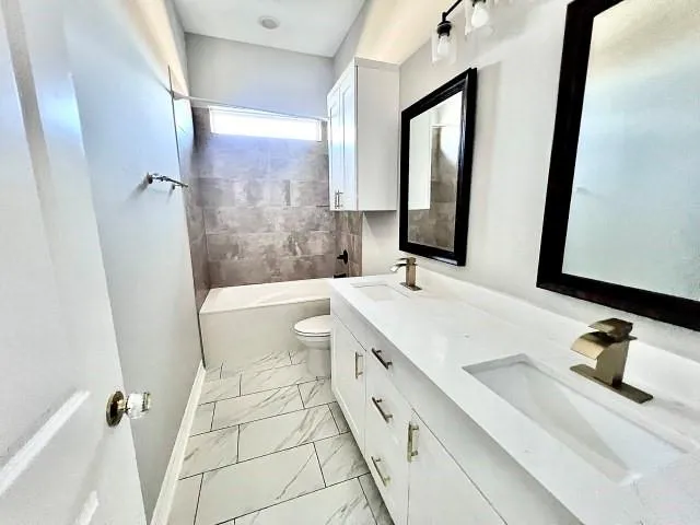 a bathroom with a sink mirror vanity and toilet