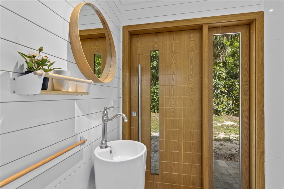 1908 37th Avenue Vero Beach, FL 32960 - Photo 27 of 34 a bathroom with a sink a mirror a potted plant and a shower