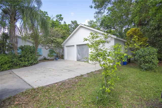 a view of a house with a small yard and a large tree