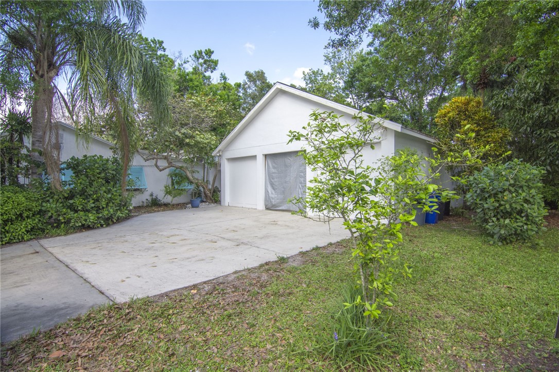 1908 37th Avenue Vero Beach, FL 32960 - Photo 30 of 34 a view of a house with a small yard and a large tree