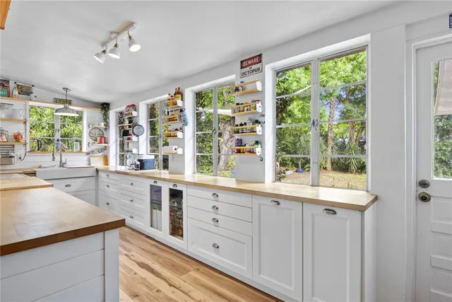 a large white kitchen with a large window