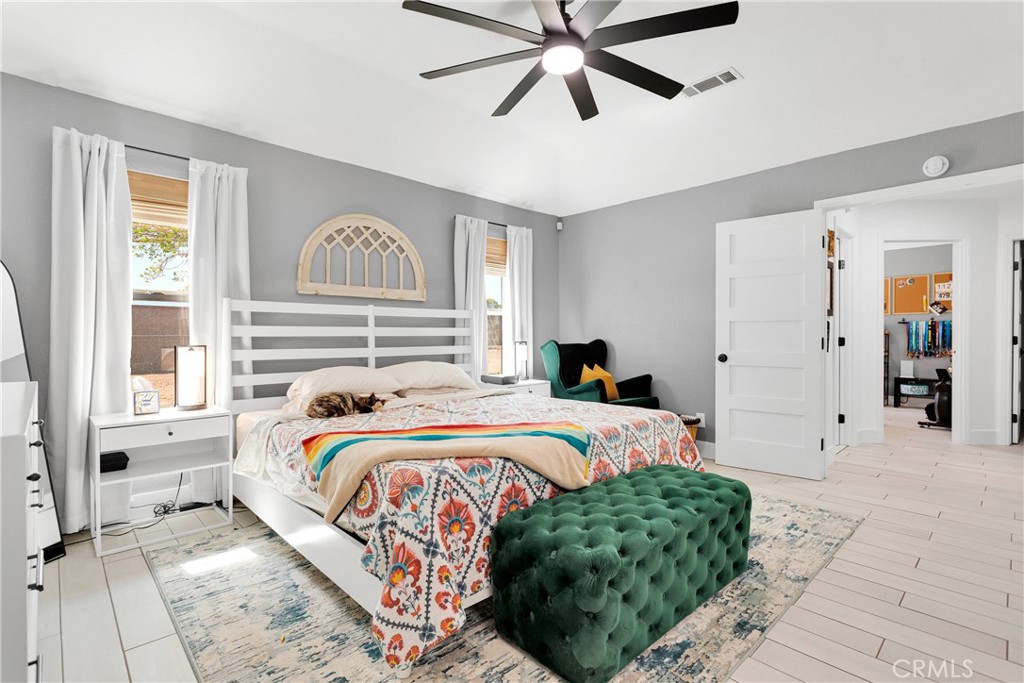 37077 Coyote Lake Road Newberry Springs, CA 92365 - Photo 25 of 58 a bedroom with a bed and a chandelier