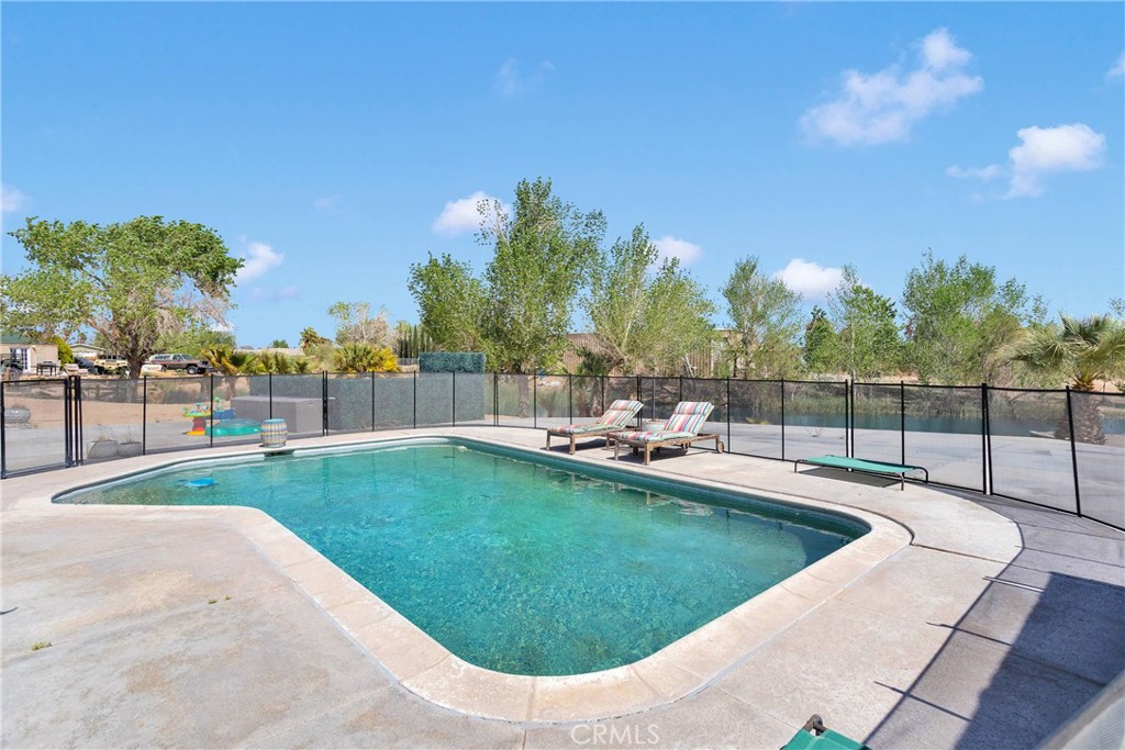 37077 Coyote Lake Road Newberry Springs, CA 92365 - Photo 37 of 58 a view of a swimming pool with a yard and sitting area