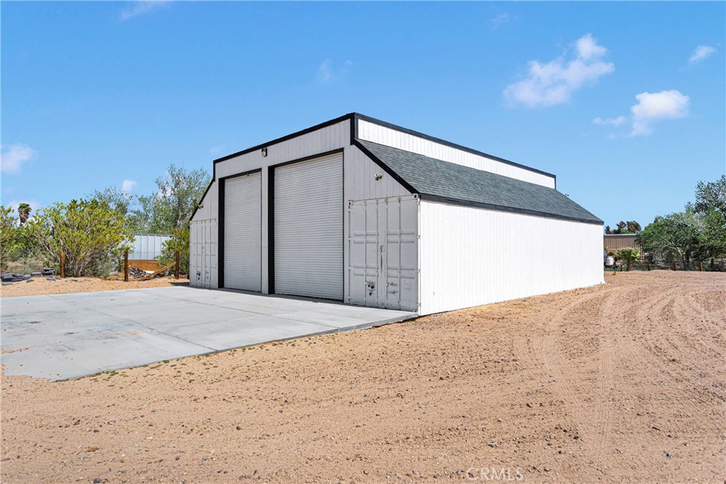 37077 Coyote Lake Road Newberry Springs, CA 92365 - Photo 46 of 58 a front view of a house with a yard and garage