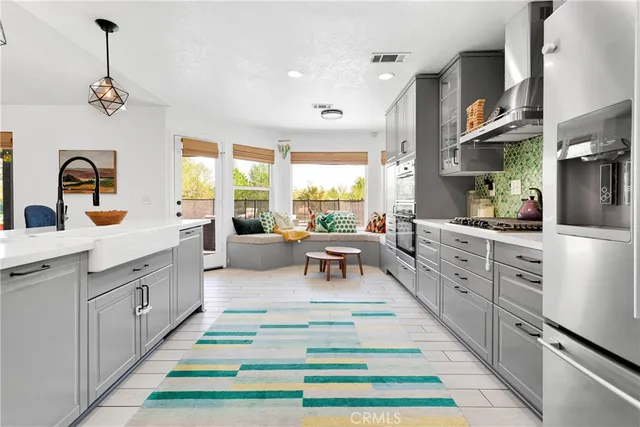 a large kitchen with stainless steel appliances kitchen island granite countertop a refrigerator a sink dishwasher a dining table and chairs with the living room view