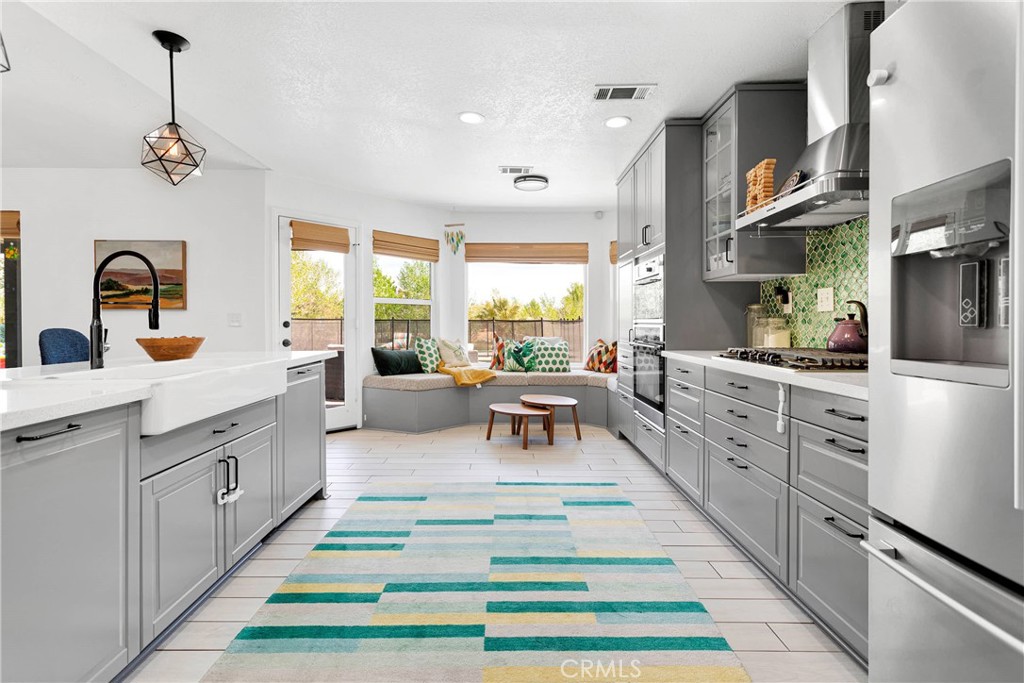 37077 Coyote Lake Road Newberry Springs, CA 92365 - Photo 7 of 58 a large kitchen with stainless steel appliances kitchen island granite countertop a refrigerator a sink dishwasher a dining table and chairs with the living room view