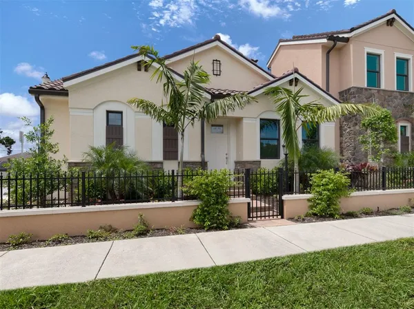 a front view of a house with a yard and potted plants