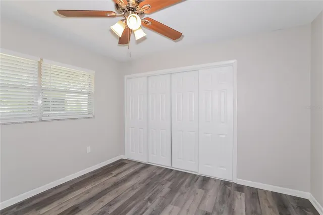 an empty room with windows and fan