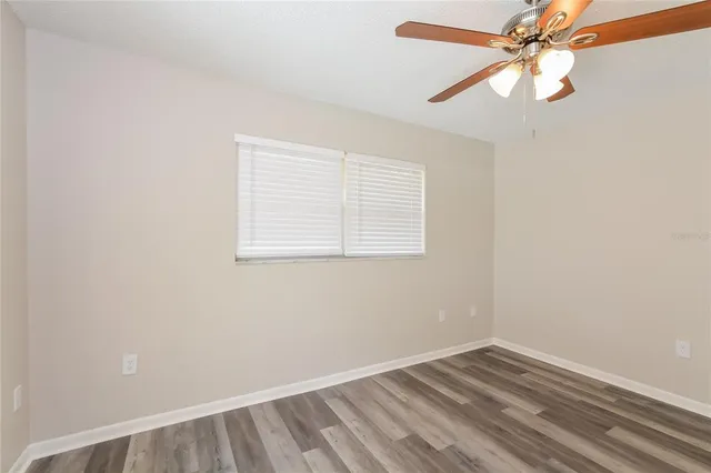 an empty room with a window and a fan
