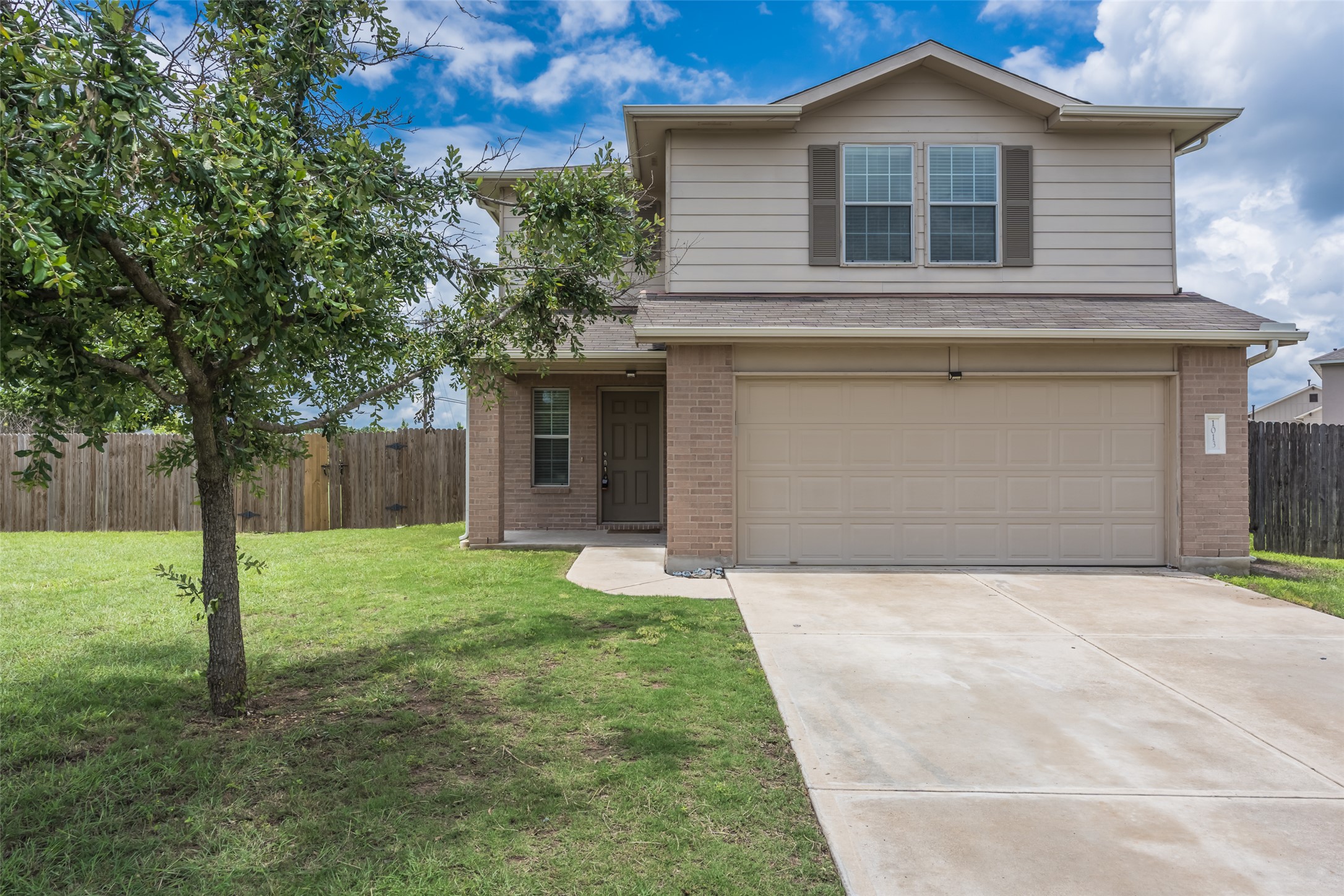 1013 Ranchero Road Leander, TX 78641 - Photo 1 of 30 A classic brick and siding exterior features a spacious concrete driveway leading to the garage.