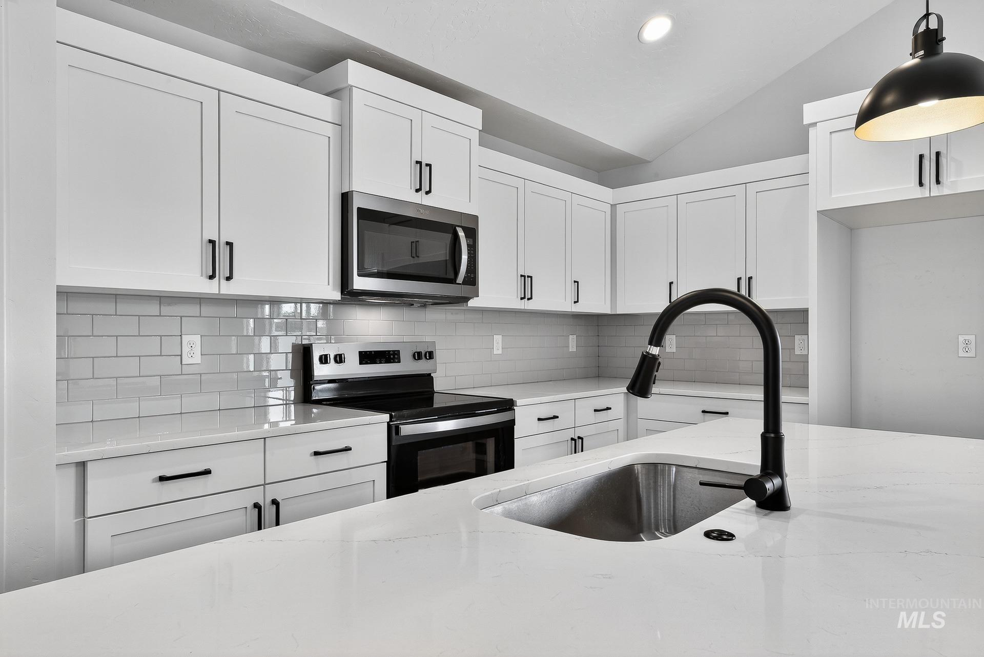 1164 Velvet Loop Wilder, ID 83676 - Photo 12 of 35 Kitchen with appliances with stainless steel finishes, white cabinetry, vaulted ceiling, decorative backsplash, and recessed lighting