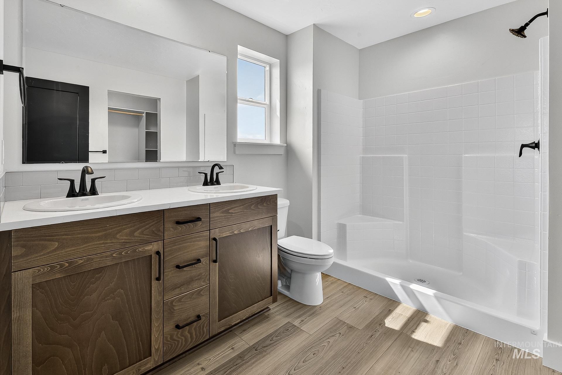 1164 Velvet Loop Wilder, ID 83676 - Photo 17 of 35 Full bath featuring double vanity, tiled shower, light wood-style flooring, and tasteful backsplash