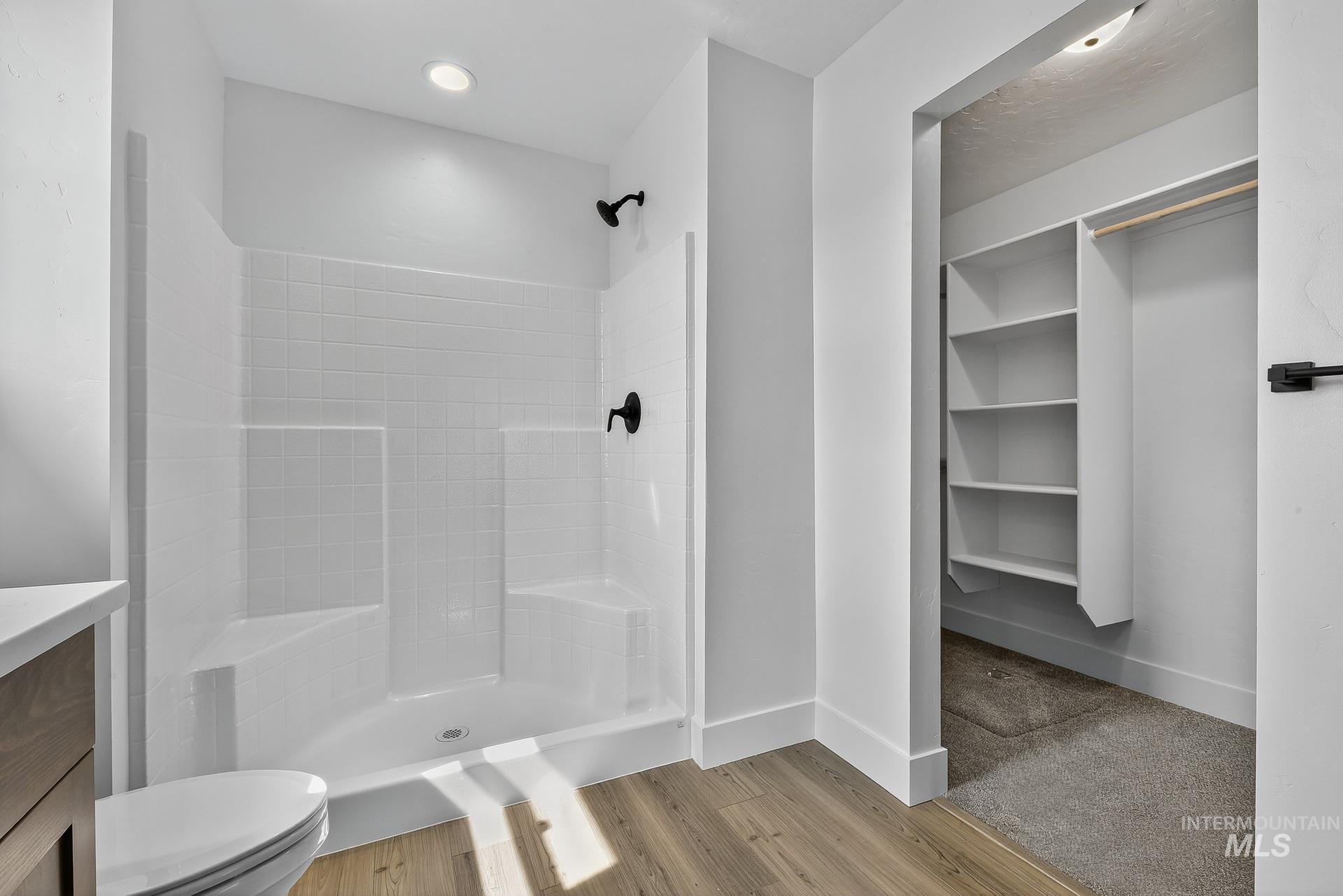 1164 Velvet Loop Wilder, ID 83676 - Photo 18 of 35 Full bath featuring a stall shower, a spacious closet, vanity, and light wood-style flooring