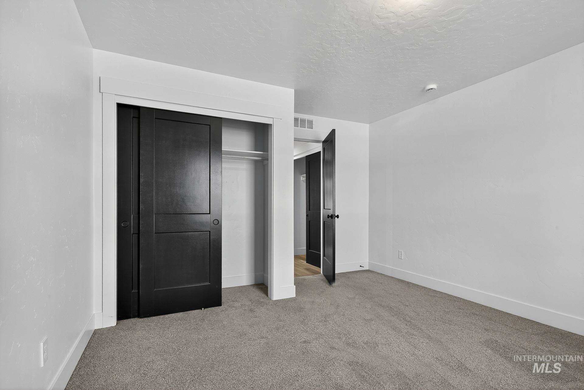 1164 Velvet Loop Wilder, ID 83676 - Photo 26 of 35 Unfurnished bedroom with carpet flooring, a closet, and a textured ceiling