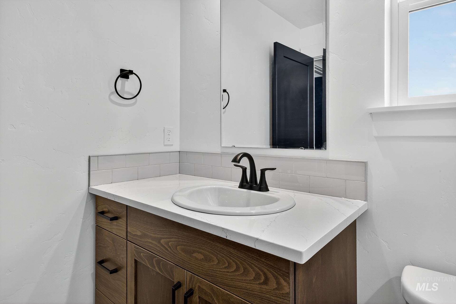 1164 Velvet Loop Wilder, ID 83676 - Photo 28 of 35 Bathroom with vanity and decorative backsplash