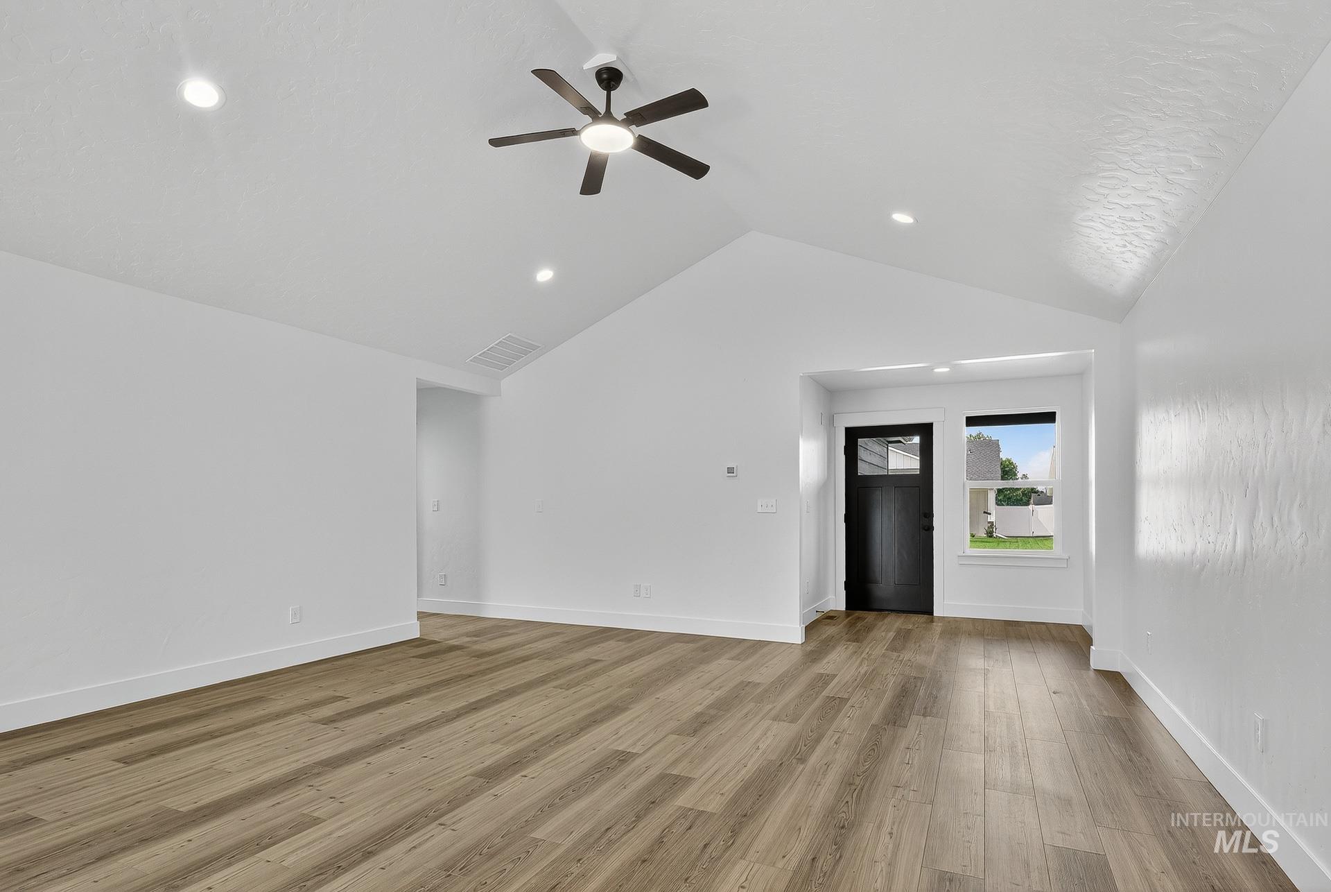 1164 Velvet Loop Wilder, ID 83676 - Photo 5 of 35 Unfurnished living room featuring ceiling fan, light wood-type flooring, recessed lighting, and high vaulted ceiling