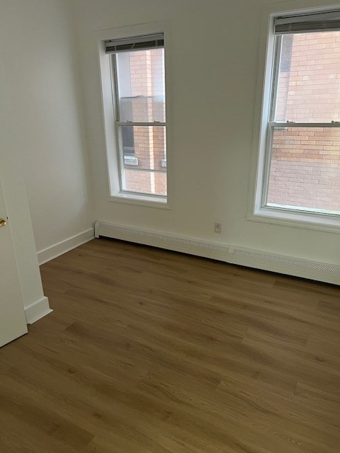 675 Washington Street, Unit 1 Brookline, MA 02446 - Photo 16 of 16 an empty room with wooden floor and windows