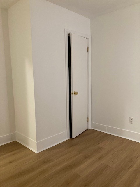 675 Washington Street, Unit 1 Brookline, MA 02446 - Photo 7 of 16 an empty room with wooden floor and closet