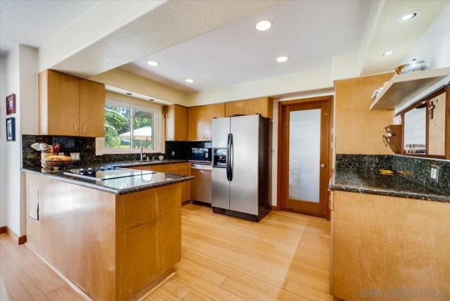a view of kitchen with stainless steel appliances granite countertop a stove and a sink