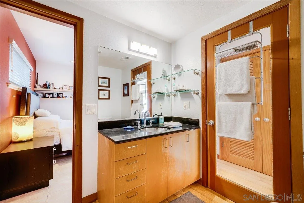 1386 Lake Drive Encinitas, CA 92024 - Photo 26 of 60 a bathroom with a granite countertop sink and a mirror