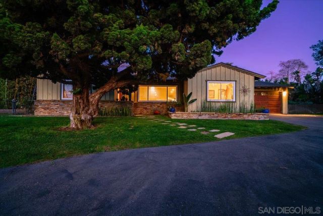 a view of a back yard with flower plants and wooden fence