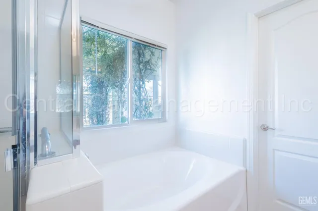 a white bath tub sitting next to a shower