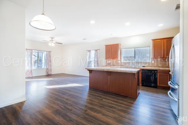 a kitchen with stainless steel appliances granite countertop a sink cabinets and wooden floor