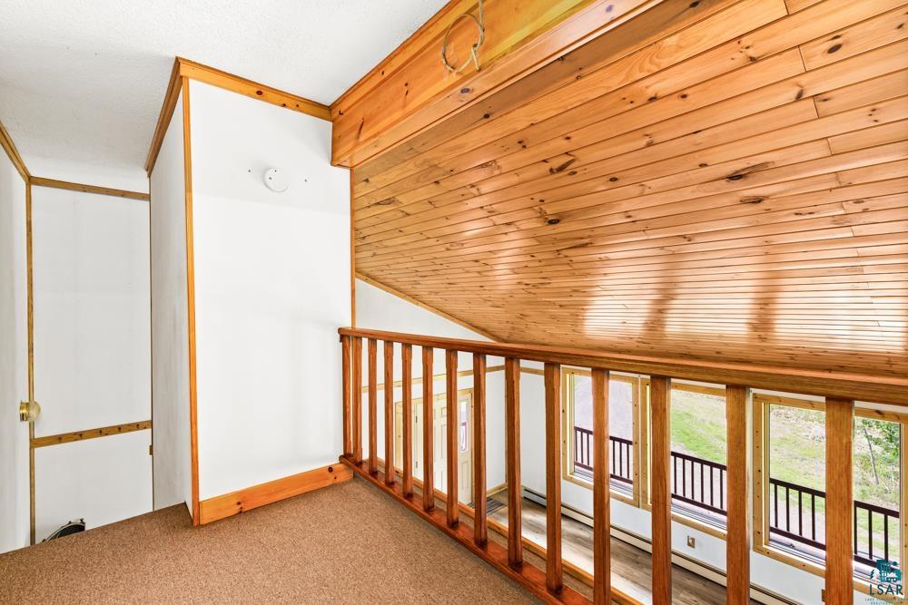 740 Seboe Road Wrenshall, MN 55797 - Photo 13 of 20 Hallway featuring carpet, a baseboard heating unit, vaulted ceiling, and wood ceiling