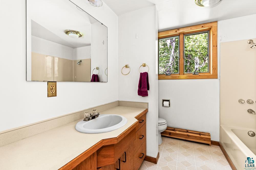 740 Seboe Road Wrenshall, MN 55797 - Photo 17 of 20 Full bathroom featuring tile patterned flooring, toilet, vanity, and shower / tub combination