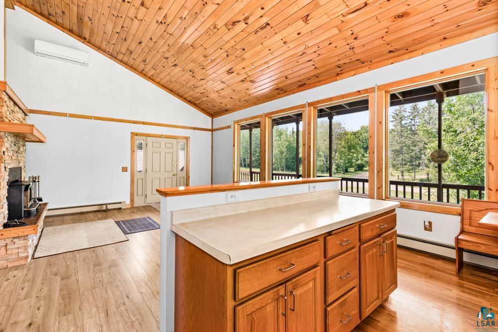 740 Seboe Road Wrenshall, MN 55797 - Photo 9 of 20 Kitchen with light hardwood / wood-style floors, baseboard heating, wooden ceiling, a fireplace, and high vaulted ceiling