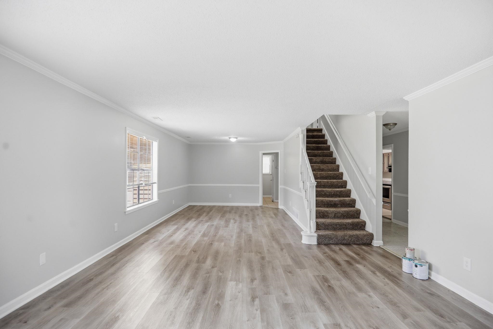 3113 Raleigh Ridge Cove Memphis, TN 38128 - Photo 8 of 38 Spacious interior with wood-finish flooring, light gray walls, white trim, and a carpeted staircase