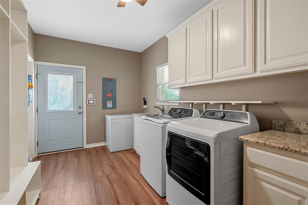 1117 Downsville Road Robinson, TX 76706 - Photo 15 of 40 Utility room with wood-finish flooring, overhead cabinetry, a window with blinds, and a built-in countertop with an integrated sink