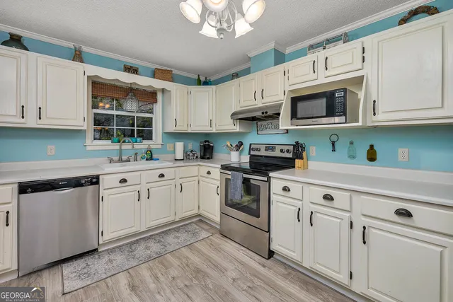 a kitchen with stainless steel appliances granite countertop white cabinets granite counter tops and a hard wood floors