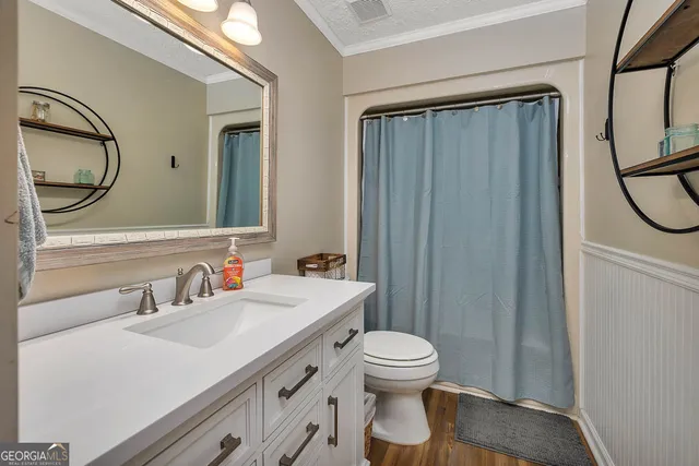 a bathroom with a toilet a sink and a mirror