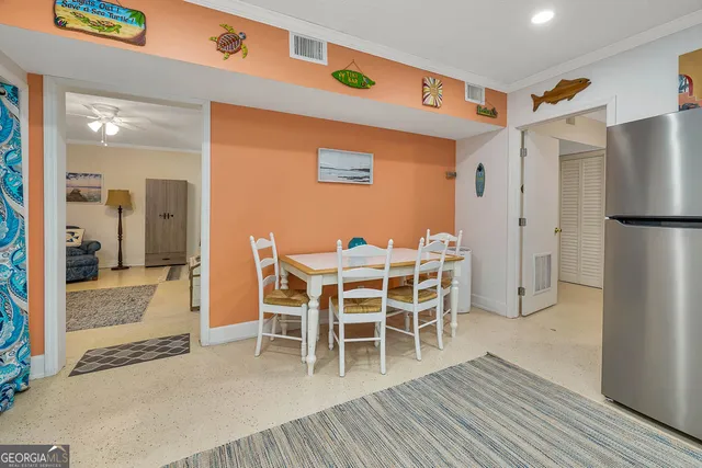 a dining room with furniture a refrigerator and wooden floor