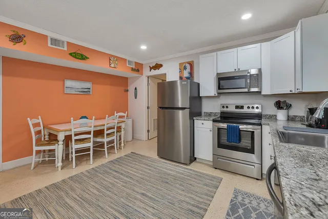 a kitchen with stainless steel appliances granite countertop a refrigerator and a stove top oven