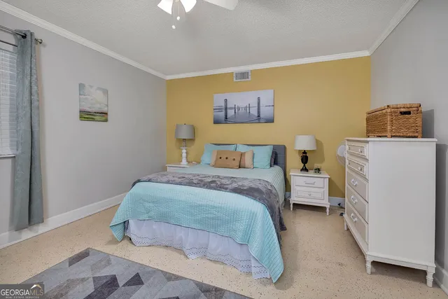 a bedroom with a bed and a lamp on the dresser