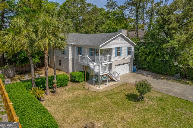 a view of a house with a yard and large trees
